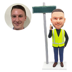 custom bobblehead figure male worker beside a guideboard