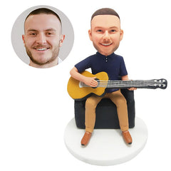 custom bobblehead figure man playing the guitar on a sofa